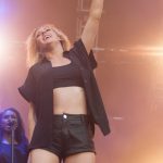 Ellie Goulding wearing a sexy mini-short and a black bra on stage